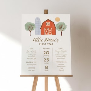 May include: A white milestone sign titled Allie Marie's First Year featuring a red barn, silo, and trees. It lists developmental milestones, stats including 20 pounds, 25 inches, and 8 teeth, favorite toy, nickname, and yummy foods in brown text.