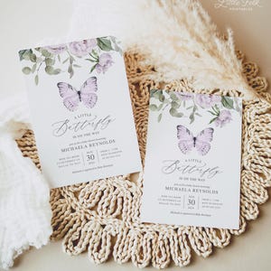 May include: Two purple and white butterfly baby shower invitations with watercolor floral designs. The text on the invitations reads "A Little Butterfly is on the Way" and includes the date, time, and location of the shower.