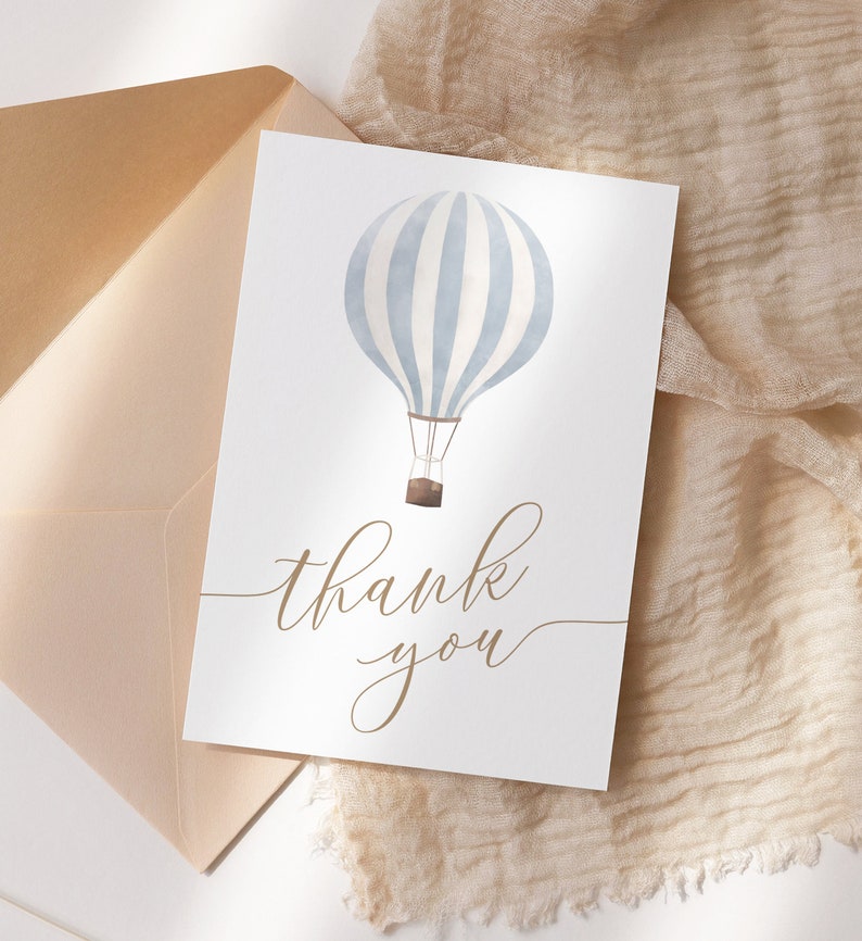 May include: A white card with a blue and white striped hot air balloon illustration and the text "thank you" in brown cursive writing.