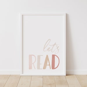 May include: White framed print with the text "let's read" in pink, orange, and beige watercolor lettering.
