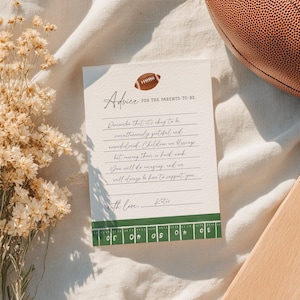 May include: A cream-colored card with the text "Advice for the Parents-to-Be" and a football illustration. The card includes handwritten advice and a green and white football field design at the bottom. A brown football is in the background.