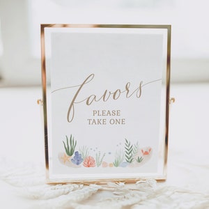Peut inclure: Une pancarte dorée avec le mot "favors" en écriture cursive et le texte "Please take one" en dessous. La pancarte présente une illustration aquarelle de coquillages, de coraux et d'algues.