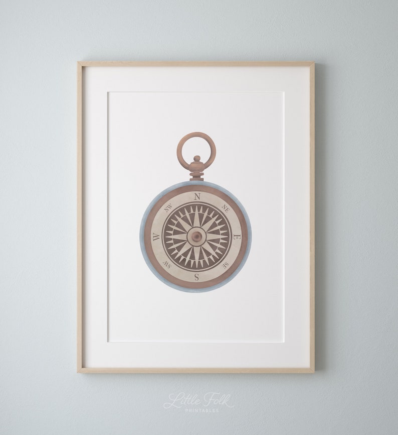 Peut inclure: Une boussole de style vintage avec un cadran en bois brun et un bo&icirc;tier en m&eacute;tal bleu. La boussole a une aiguille blanche pointant vers le nord et les points cardinaux sont &eacute;tiquet&eacute;s en noir.