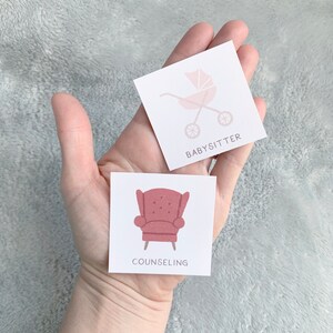 Pu&ograve; includere: Due carte bianche con illustrazioni e testo rosa. La prima carta mostra un passeggino rosa con il testo "BABYSITTER". La seconda carta mostra una poltrona rosa con il testo "COUNSELING".