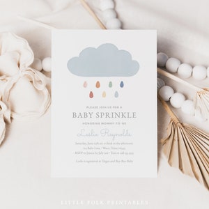 May include: A baby sprinkle invitation featuring a blue cloud and colourful raindrops. The invitation reads "Please join us for a baby sprinkle honouring mommy-to-be Leslie Reynolds".