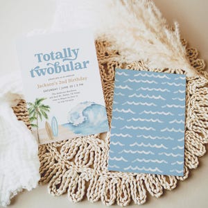 Könnte beinhalten: Zweiseitige Einladungskarte mit Strandmotiv. Die Vorderseite zeigt den Text "Totally twobular" und Details für eine zweite Geburtstagsfeier. Die Rückseite hat ein blaues Wellenmuster. Die Karte ist mit einer Aquarellillustration einer Welle, einer Palme und Surfbrettern verziert.
