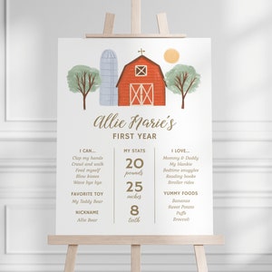 May include: A white milestone sign featuring a red barn, blue silo, and green trees. The text reads Allie Marie's FIRST YEAR, I CAN, MY STATS 20 pounds 25 inches 8 teeth, I LOVE, FAVORITE TOY, NICKNAME, and YUMMY FOODS with various listed details.