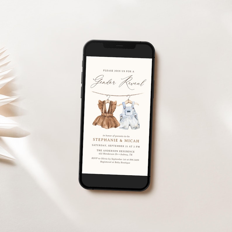 May include: A smartphone screen displaying a gender reveal party invitation. The invitation features a watercolor illustration of two baby outfits hanging on a clothesline. The text reads "Please join us for a Gender Reveal" and includes the names Stephanie and Micah, the date and time of the event, and the location.