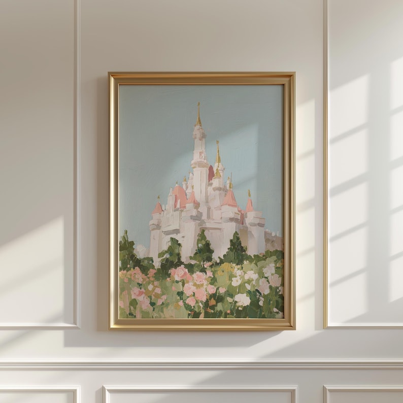 May include: A framed painting of a fairytale castle with pink turrets and gold spires, set against a light blue sky. The castle is surrounded by a garden of pink and white flowers and green foliage. The frame is gold.