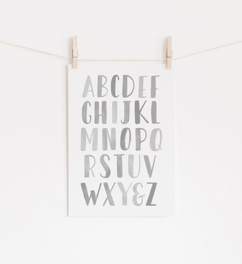 May include: A printable alphabet poster with a watercolor gradient background. The letters are in a bold, handwritten font and range from light gray to dark gray.