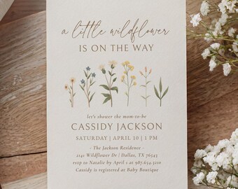 May include: A baby shower invitation with a floral design. The text reads "a little wildflower is on the way" and "let's shower the mom-to-be Cassidy Jackson Saturday | April 10 | 1 PM -The Jackson Residence- 2141 Wildflower Dr | Dallas, TX 76543 rsvp to Natalie by April 1 at 987.654-3210 Cassidy is registered at Baby Boutique"