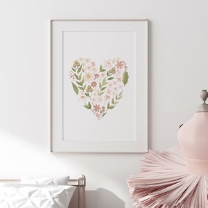 May include: A framed print of a watercolor painting of a heart shape made of pink, white, and green flowers.