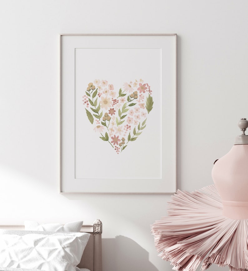 May include: A framed print of a watercolor painting of a heart shape made of pink, white, and green flowers.
