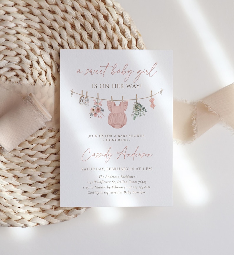 May include: A pink baby shower invitation with a watercolor illustration of baby clothes hanging on a clothesline. The text reads "a sweet baby girl is on her way!" and includes the name "Cassidy Anderson" and details for the baby shower.