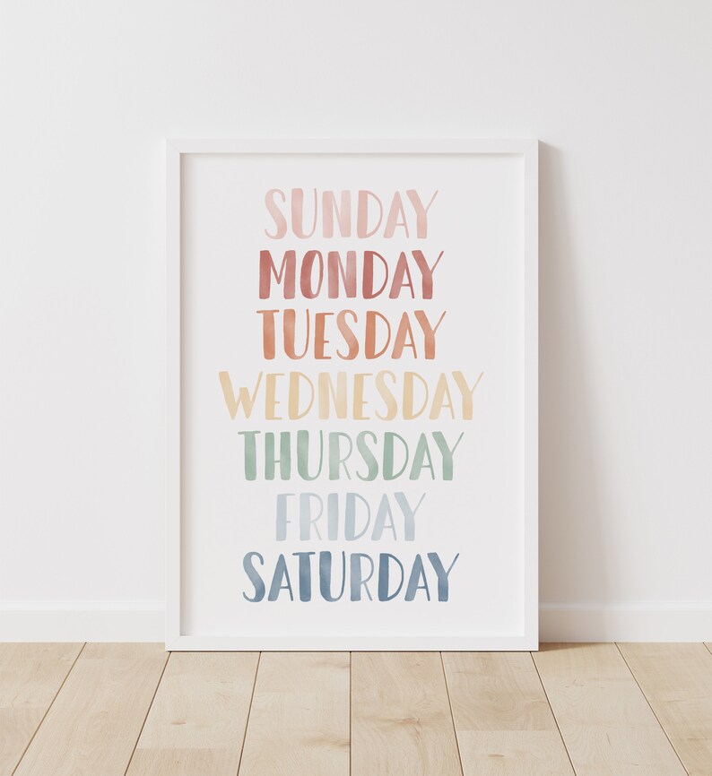 Puede incluir: Una impresi&oacute;n enmarcada en blanco con los d&iacute;as de la semana escritos en una fuente de acuarela colorida. Los colores pasan del rosa al azul.