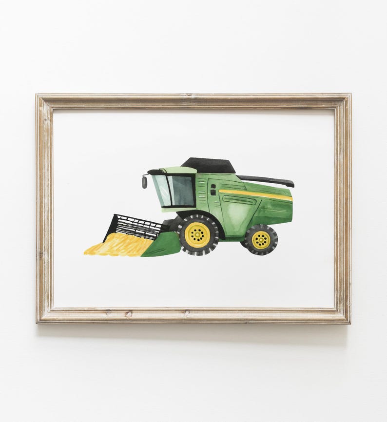 May include: Watercolor illustration of a green and yellow combine harvester, framed in a light brown wooden frame. The farm equipment is depicted in a side view, with a black header and yellow wheels. The artwork is set against a white background.