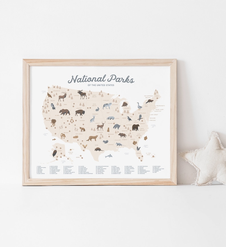 Puede incluir: Un mapa ilustrado beige y marr&oacute;n de los Estados Unidos que muestra las ubicaciones de todos los Parques Nacionales. Cada parque est&aacute; marcado con un peque&ntilde;o icono que representa un animal nativo que se encuentra en ese parque. El mapa est&aacute; enmarcado en un marco de madera claro. El texto "National Parks of the United States" est&aacute; en la parte superior del mapa.