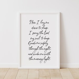 May include: A white framed print with black calligraphy text. The text reads "Now I lay me down to sleep. I pray the lord my soul to keep. Guide me safely through the night, and wake me with the morning light."