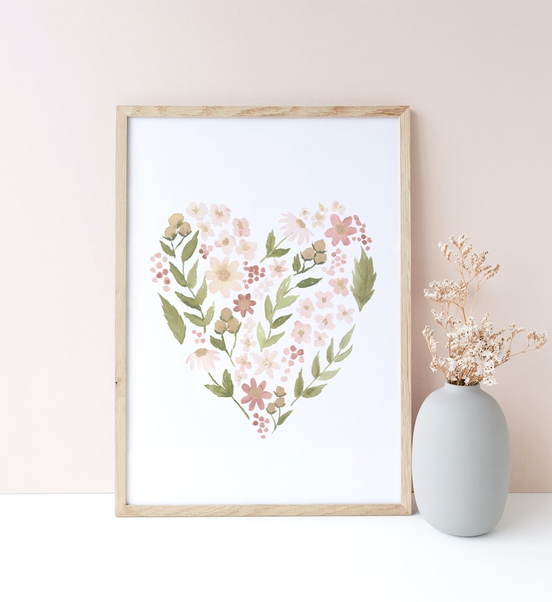 May include: A framed print of a watercolor painting of a heart shape made of pink, white, and green flowers. The print is on a white background and is framed in a light wood frame.