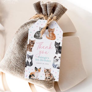Op de afbeelding: Een cadeauzakje van jute met een label met aquarel illustraties van kittens. Het label leest "Thank you" en "Raleigh's 5th Birthday, August 20, 2024". Het zakje is vastgebonden met touw.