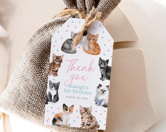 May include: A gift bag with a tag featuring watercolor illustrations of kittens. The tag reads "Thank you" and "Raleigh's 5th Birthday, August 20, 2024". The bag is made of burlap and tied with twine.
