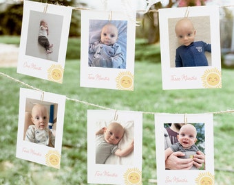 May include: A series of six photographs of a baby, each labeled with a month from one to six. The photos are clipped to a string with small gold clips. Each photo has a smiling sun graphic.