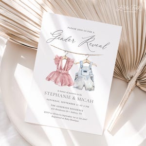 May include: A gender reveal invitation with a watercolor illustration of two baby outfits hanging on a clothesline. The text reads "Please join us for a Gender Reveal" and includes the names Stephanie & Micah, the date and time of the event, and the location.