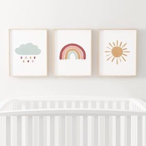 Puede incluir: Tres impresiones enmarcadas con un dise&ntilde;o minimalista. La primera impresi&oacute;n presenta una nube azul claro con gotas de lluvia rojas cayendo de ella. La segunda impresi&oacute;n presenta un arco&iacute;ris con rayas rojas, naranjas, amarillas, verdes y azules. La tercera impresi&oacute;n presenta un sol amarillo con rayos naranjas.