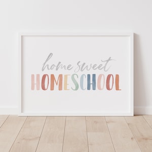 May include: White framed print with the text "home sweet HOMESCHOOL" in a rainbow watercolor font.