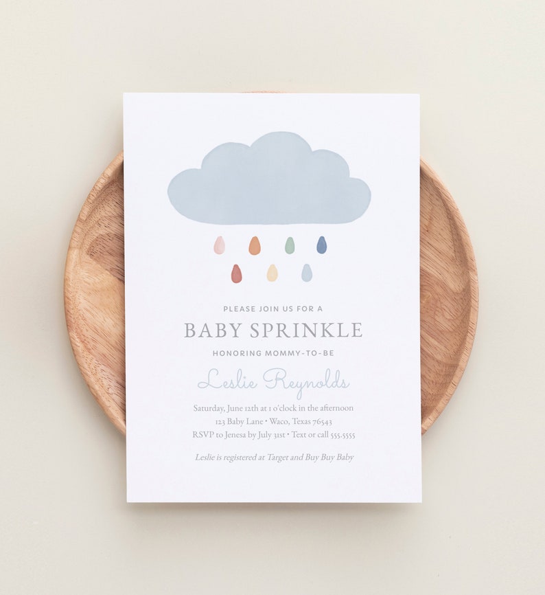 May include: A baby sprinkle invitation featuring a blue cloud and colourful raindrops. The invitation is for Leslie Reynolds and includes the date, time, location, and RSVP details.