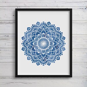 May include: A blue and white mandala design with intricate details. The mandala is framed in a black frame and is set against a white background.
