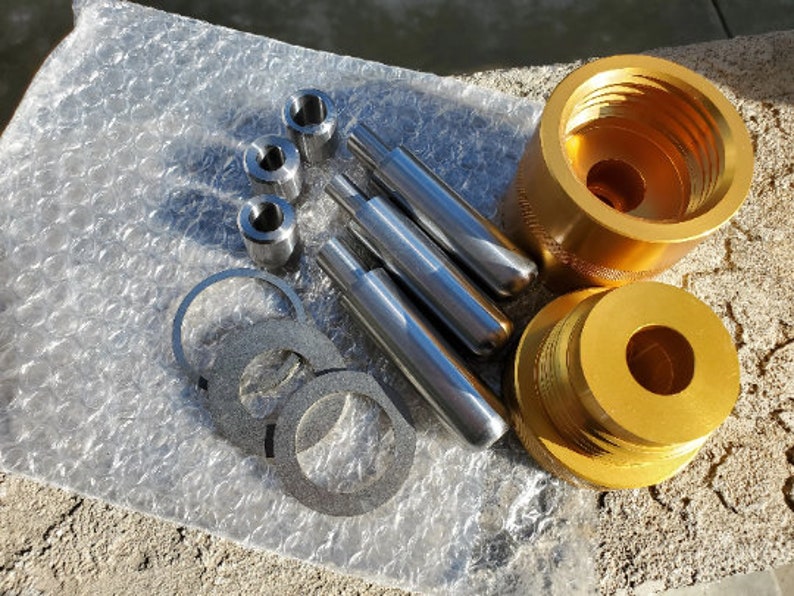 May include: A set of gold-colored metal tools for making jewelry. The set includes a variety of sizes of round metal punches, a metal ring mandrel, and a metal ring sizer.