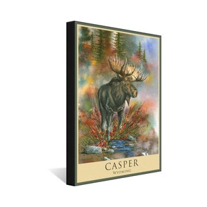 K&ouml;nnte beinhalten: Ein Aquarellbild eines Elchs, der in einem Bach steht, mit rotem und gelbem Laub im Hintergrund. Der Text "CASPER WYOMING" befindet sich am unteren Rand des Bildes.