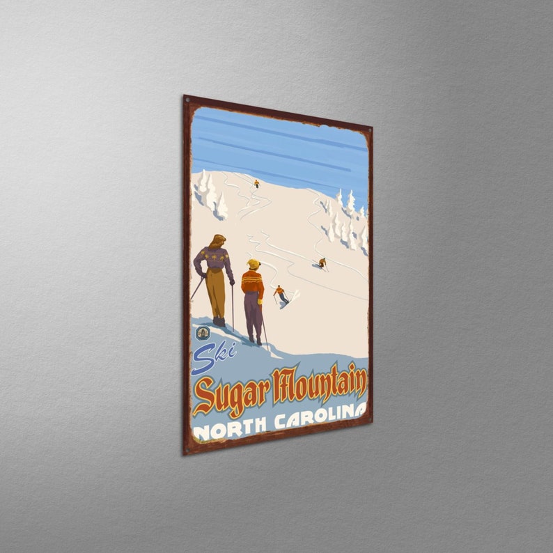 May include: Vintage metal sign featuring a ski scene at Sugar Mountain in North Carolina. The sign depicts skiers on a snowy slope with a blue sky and stylized trees. The sign has a rusty brown border and the words "Ski Sugar Mountain North Carolina".