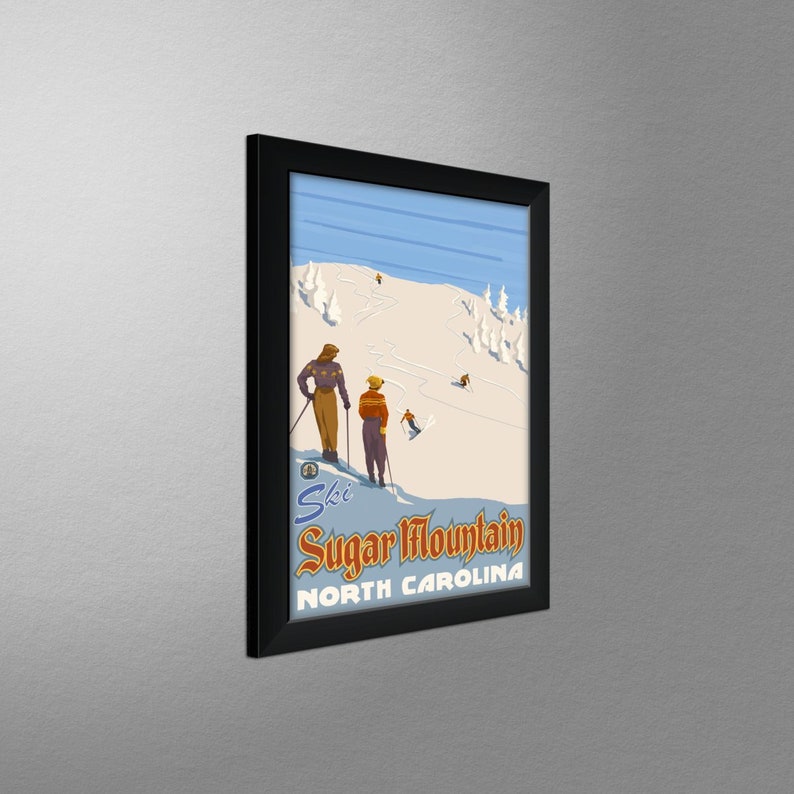 May include: Framed vintage-style poster featuring a ski scene at Sugar Mountain, North Carolina. The artwork depicts skiers on a snowy slope with trees and a blue sky. The poster has a black frame.