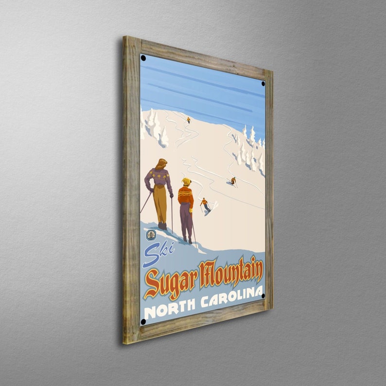 May include: A framed vintage-style poster featuring a ski scene at Sugar Mountain, North Carolina. The artwork depicts skiers on a snowy slope with a blue sky. The poster is in a rustic wooden frame.