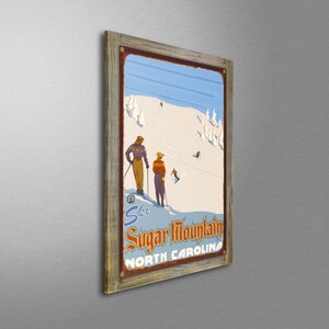 May include: Vintage-style framed print featuring a ski scene at Sugar Mountain, North Carolina. The artwork depicts skiers on a snowy slope under a blue sky. The frame is made of rustic wood, adding a classic touch to the winter sports theme.