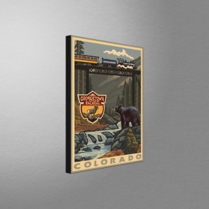 May include: A vintage-style illustration of a train crossing a bridge in a mountainous landscape. The text "Georgetown Loop Railroad" and "Colorado" are visible. A black bear stands on a rock in the foreground.