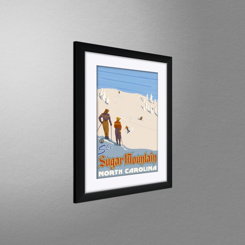 May include: Framed vintage ski poster for Sugar Mountain, North Carolina. The artwork features skiers on a snowy slope, with the words "Ski Sugar Mountain North Carolina" in a retro font. The poster is framed in a black frame.