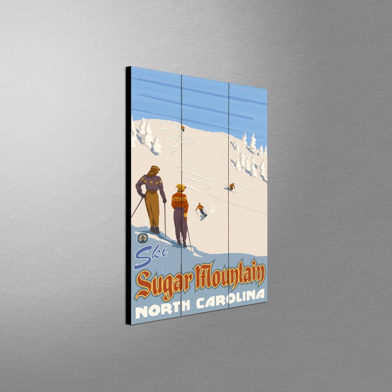 May include: A vintage-style wooden wall art piece featuring a ski scene at Sugar Mountain, North Carolina. The artwork depicts skiers on a snowy mountain with a blue sky and text that reads "Ski Sugar Mountain North Carolina."