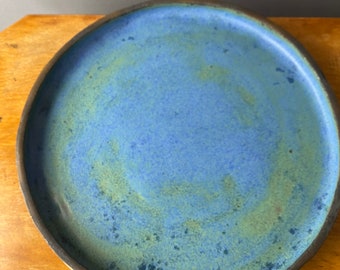 PLATE: A hand made stoneware plate with blue, green and bronze/rose gold glazes. [U6]