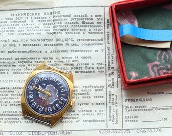 Puede incluir: Un reloj de pulsera dorado con una esfera negra y marcas blancas. La esfera del reloj presenta un mapa de la Antártida. El reloj viene acompañado de una caja roja y un documento de papel con texto en ruso.