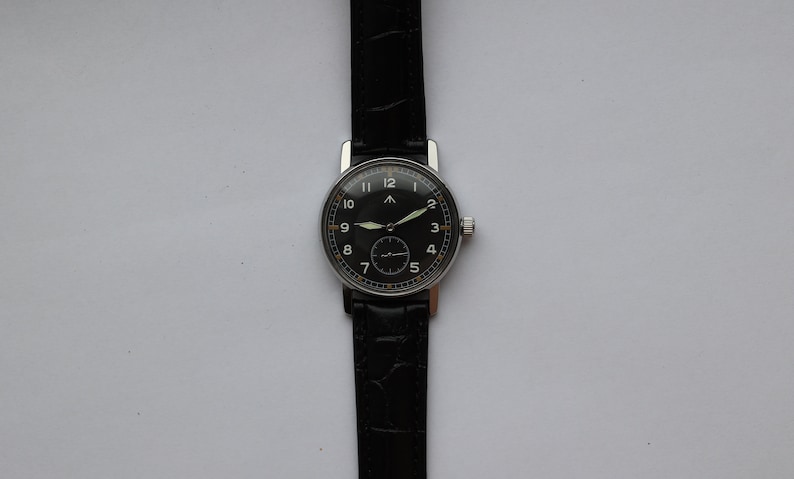 May include: A black-faced wristwatch with white numerals and a silver case. The watch has a black leather band.