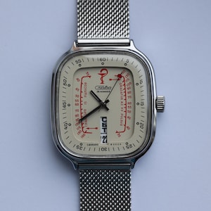 May include: Vintage silver-toned wristwatch with a mesh band. The watch face is off-white with red and black markings, including a pulse scale and the text "Слава". The date is displayed at the bottom.