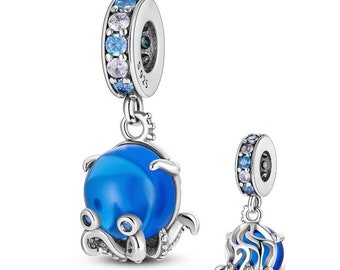 May include: Two silver charm pendants with blue and clear accents. One pendant features a blue orb with an octopus design, the other has a blue orb with a cage-like design. The charms have a ring with blue and clear stones.