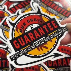 May include: A circular sticker featuring a yellow and red design with a black devil tail and horns. The text reads OUR 666% GUARANTEE and THAT NO ONE IN THE HISTORY OF TORTURE HAS BEEN TORTURED WITH TORTURE LIKE THE TORTURE YOU'LL BE TORTURED WITH.