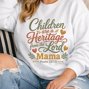 Puede incluir: Sudadera blanca con la frase bordada "Children are a Heritage from the Lord Mama" en verde, naranja y dorado. El diseño incluye corazones y hojas, con "Psalm 127:3" debajo. Una prenda cómoda e inspiradora.