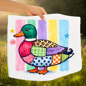Könnte beinhalten: Ein weißes Kissen mit einem farbenfrohen Patchwork-Enten-Design. Die Ente hat einen grünen Kopf, einen orangefarbenen Schnabel und einen Körper aus verschiedenen gemusterten Flicken. Vertikale Streifen in Rosa, Gelb, Lila und Blau sind im Hintergrund, mit Stern- und Blumenakzenten.