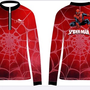 May include: Red long-sleeve shirt featuring a white spiderweb design. The front has a partial zipper and a small logo. The back displays a Spider-Man graphic and the words "Spider-Man" in white.