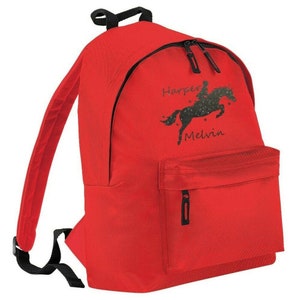 May include: A red backpack with black zippers, straps, and a handle. The front of the backpack features a black graphic of a horse and rider with the names "Harper Melvin" in script.